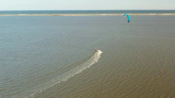 Вид с воздуха на плавание кайтсерферов и прыжки через океан — стоковое видео