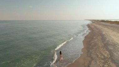 ince sportif kadın deniz kıyısında sabahın erken saatlerinde tek başına çalıştırılır