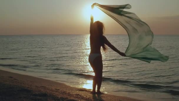 Slim νεαρή γυναίκα χορεύει στην παραλία το ηλιοβασίλεμα. — Αρχείο Βίντεο