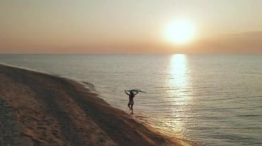 ince sportif kadın deniz kıyısında sabahın erken saatlerinde tek başına çalıştırılır. Havadan görünüm