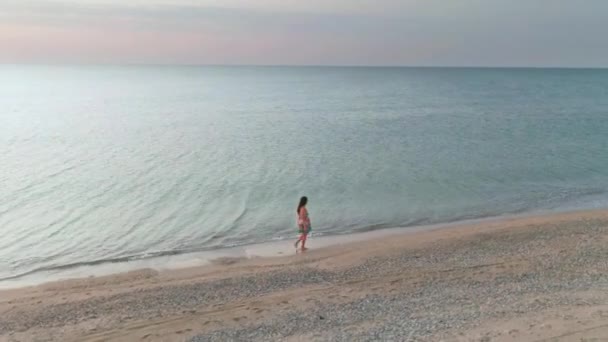 Mulher esportiva magro é executado sozinho no início da manhã no litoral. Vista aérea — Vídeo de Stock