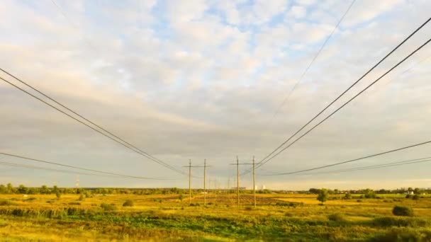 Caducidad de los pilones eléctricos y de la línea eléctrica de alta tensión al atardecer. Fondo de hermoso cielo nublado . — Vídeos de Stock