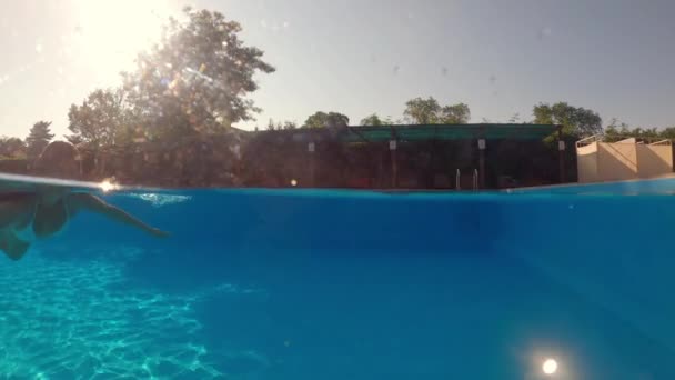 Strzelanina pod wodą. Dziewczyna nurkowanie w niebieskim basenie. — Wideo stockowe