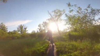 Bir çocuk ormanda bir yolda bisiklete biniyor. Bahar parkındaki yol..