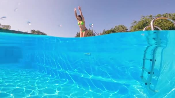Tragere subacvatică. Fata se scufundă în piscină albastră . — Videoclip de stoc