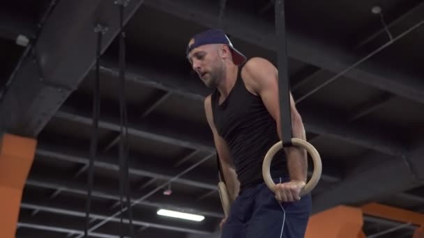 Koppig moe fitness man doen ring dips training in de sportschool — Stockvideo