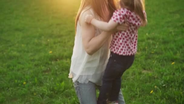 Mutter wirft ihr entzückendes Kind bei Sonnenuntergang im Park in die Luft — Stockvideo