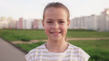 Karşı kentsel çim gülümseyen küçük neşeli kız