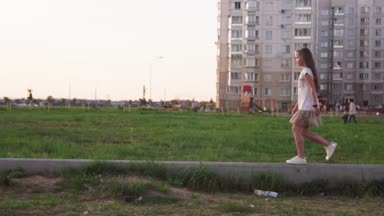 Sevimli küçük kız beton oturum açma şehir çim yürüyüş