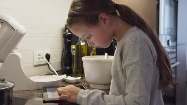 Petite Fille Regarde Écran Tablette Prépare Nourriture Dans Cuisine Moderne — Video
