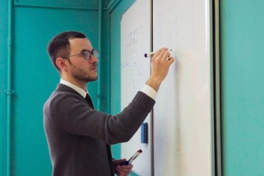 Beyaz tahta'Üniversitesi sınıf üzerinde adam öğretmen yazıyor