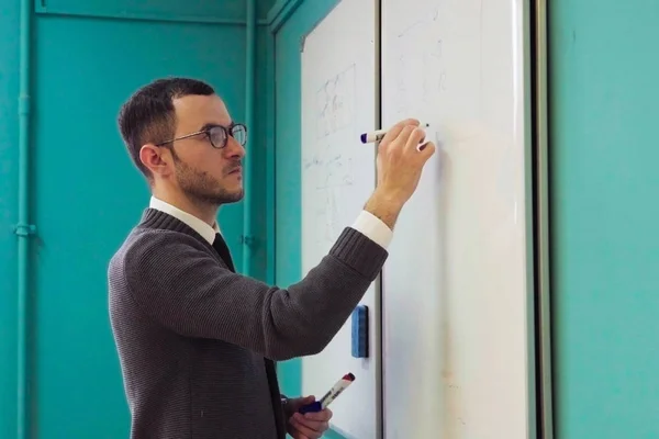 Beyaz tahta'Üniversitesi sınıf üzerinde adam öğretmen yazıyor