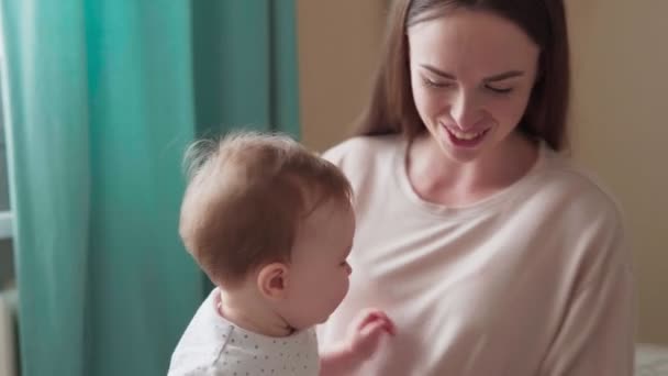 Glückliche Mutter küsst und umarmt ihr kleines Baby — Stockvideo