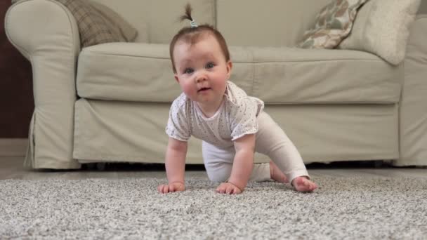 Schattige onhandige baby glimlachen en kijken naar camera op verdieping — Stockvideo