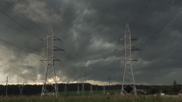 Dark overcast stormy sky against electric power pylons of transmission line — Stock Video