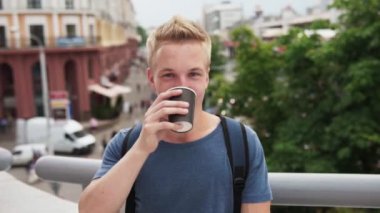Kahve içme ve kentsel Sokağı'nda gülümseyen genç yakışıklı sarışın adam
