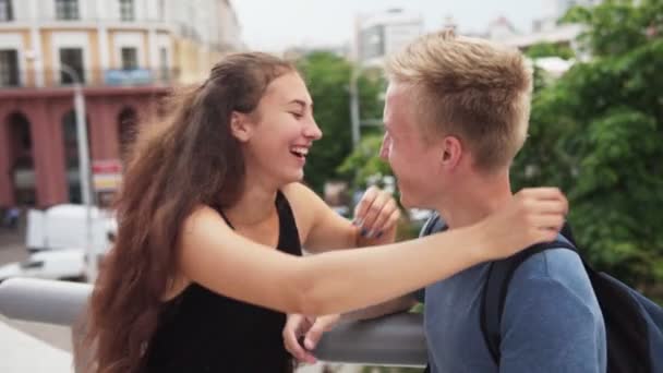 Joven pareja alegre abrazándose y riendo en la ciudad — Vídeo de stock