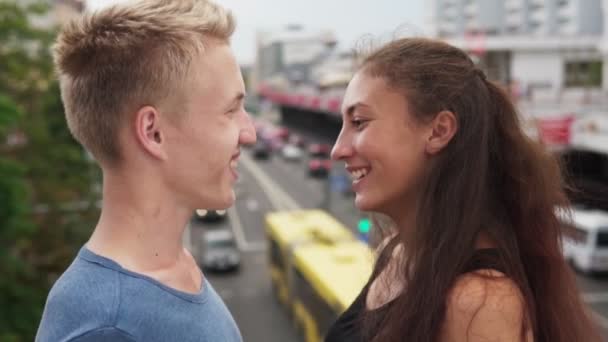 Chico y chica se miran con ojos cariñosos en la calle de la ciudad — Vídeos de Stock