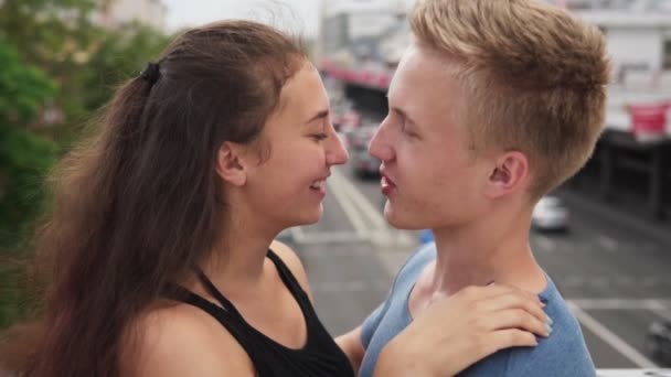 Gelukkig meisje verliefd hugs zachtjes haar vriendje op zomerdag in de stad — Stockvideo