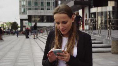 Ciddi bir iş kadın kentsel Sokağı'nda Smartphone kullanarak