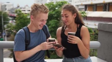 Kahve içme ve şehir sokak smartphone kullanarak genç mutlu çift