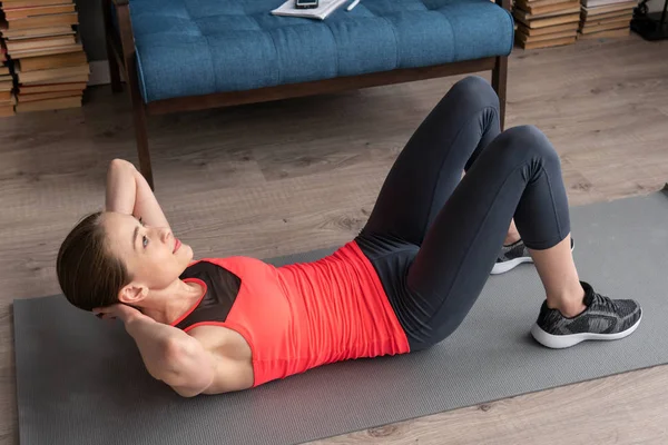 Fitness žena dělá crunch cvičení na podlaze doma — Stock fotografie