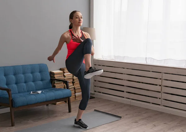 Kadının evde Fitness eğitimi ve dizler yürüyüş yapması