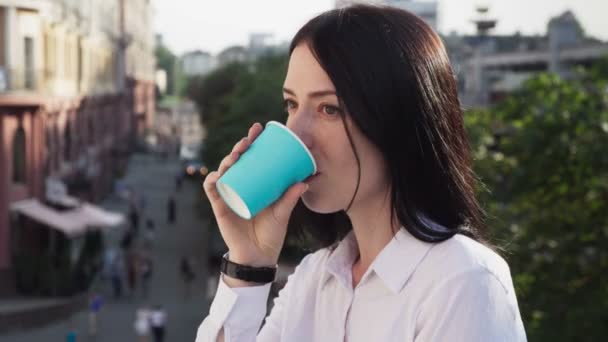 Уверенная деловая женщина пьет кофе отдыхая и улыбаясь на городской улице — стоковое видео