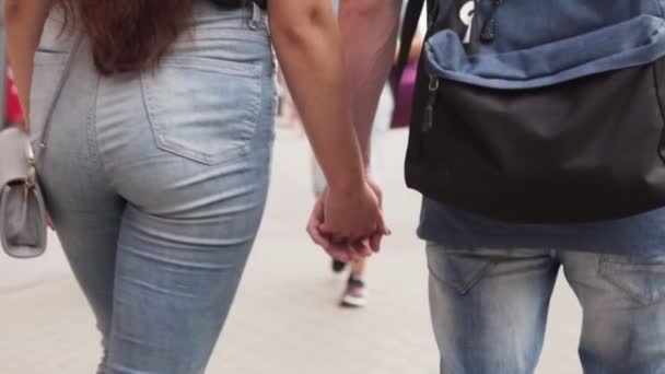 Young couple of lovers holding hands and walking together on city street — Stock Video