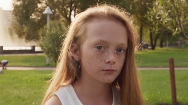 Sonhando menina ruiva com sardas olha para cima no dia ensolarado de verão — Vídeo de Stock