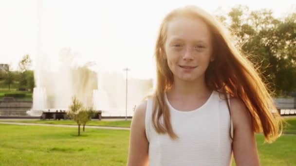 Menina ruiva feliz com sardas andando na luz do sol no parque de verão — Vídeo de Stock