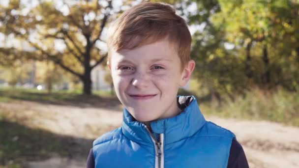 Happy little boy smiling without front primary tooth on sunny autumn day — Stock Video