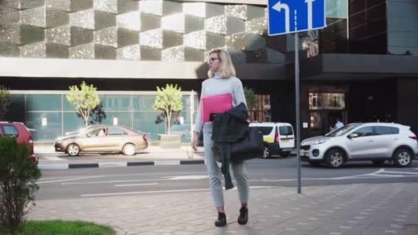 Joven estudiante de pie con carpeta y en busca de trabajo en la calle urbana — Vídeo de stock