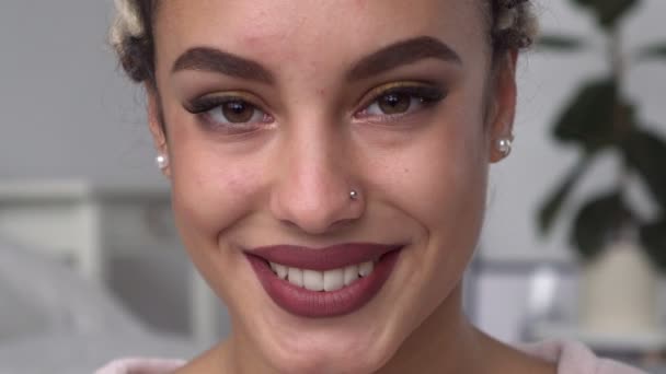 Fiatal, csinos nő keresi a kamera, és mosolyogva — Stock videók