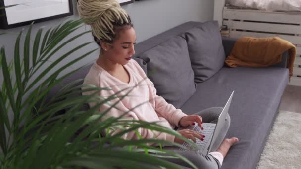 Joven mujer de negocios trabajando en el ordenador portátil mirando a la cámara y sonriendo en casa — Vídeo de stock