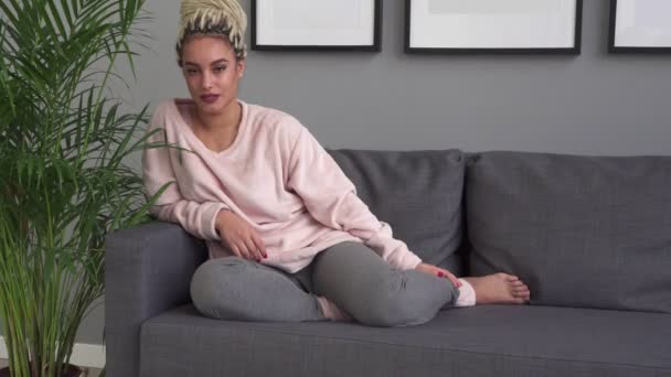 Gelukkig jonge hipster vrouw die lacht tijdens de vergadering op comfortabele sofa thuis — Stockvideo