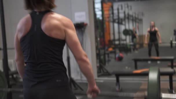 Fitness kvinna skivstång push press träning framför spegeln i gymmet — Stockvideo