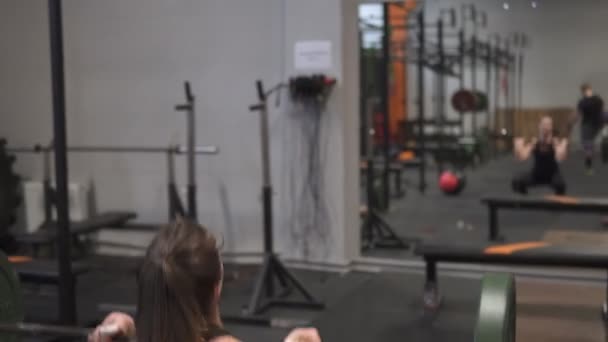 Mujer de fitness haciendo ejercicio de levantamiento de pesas delante del espejo en el gimnasio — Vídeo de stock