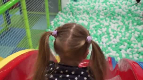Meisje naar beneden dia op speelplaats in childrens center — Stockvideo