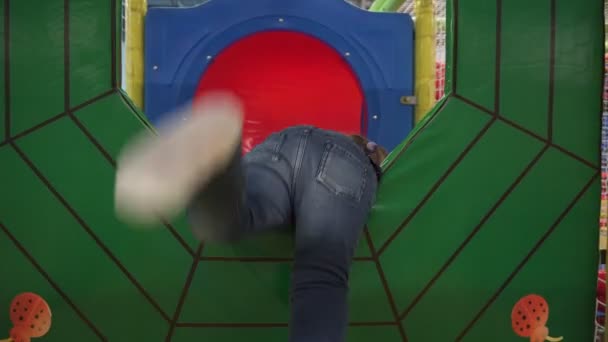Дівчина рухається через лабіринт на дитячій перешкоді на дитячому майданчику — стокове відео
