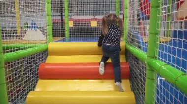 Mutlu küçük kız oyun çocuk Merkezi üzerinde slayt aşağı taşıma