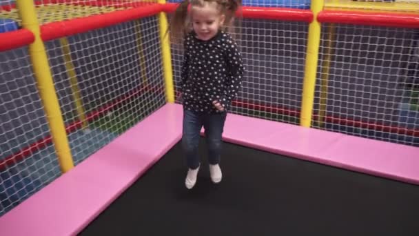 Kleines Mädchen springt auf Trampolin auf Kinderspielplatz — Stockvideo