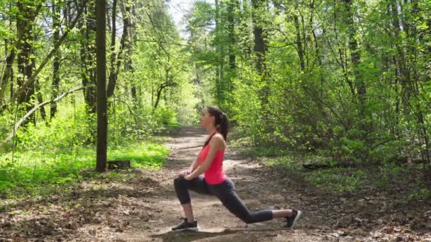 Kobieta robi rozciąganie przed bieganiem w lesie — Wideo stockowe