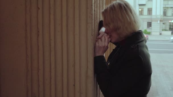 Δυστυχισμένη γυναίκα που κλαίει κοντά στον τοίχο στην πόλη — Αρχείο Βίντεο