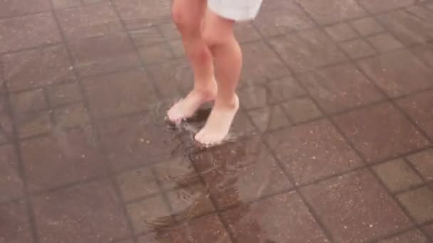 Kleine jongen Barefoot springt en speelt in plas op City Street — Stockvideo