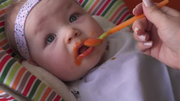 Mothers hand feeds baby with spoon — Stock Video