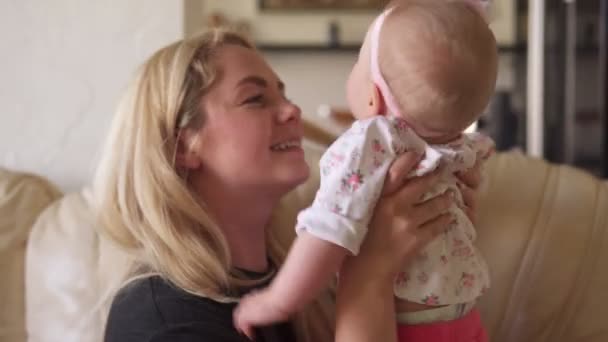 Mãe feliz brincando com bebê adorável no sofá em casa — Vídeo de Stock