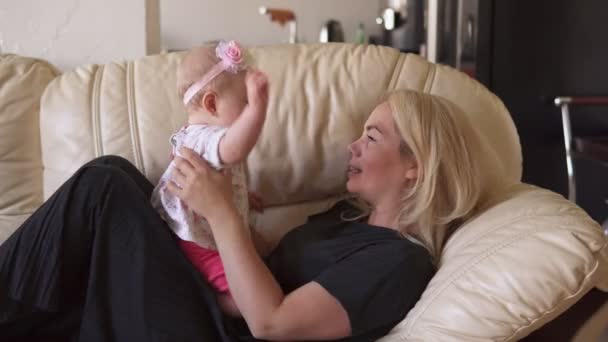 귀여운 아기 소녀 재생 와 어머니 에 소파 — 비디오