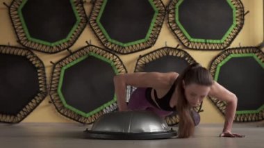 Zıplayan kadın spor salonunda şınav çekiyor.