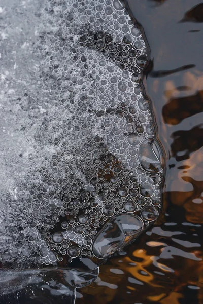 水の乱流流れの背景に氷の薄い地殻の下の空気の泡の蓄積 — ストック写真